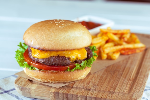 Hamburguesa y papas fritas en la mesa de madera