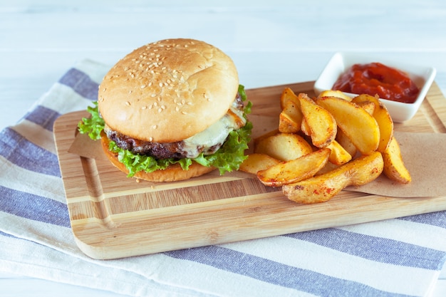 Hamburguesa y papas fritas en la mesa de superficie de madera