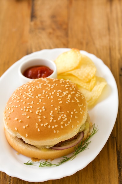 Hamburguesa con papas fritas y salsa en el plato