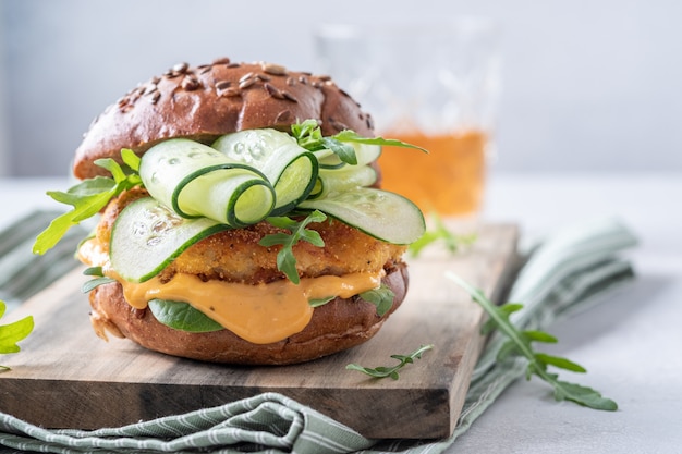 Hamburguesa de pescado con pepino en una tabla de cortar