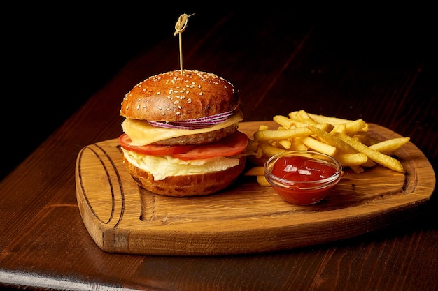 Hamburguesa de pollo de comida rápida americana en una tabla de madera. Fondo de madera oscura. Enfoque selectivo.