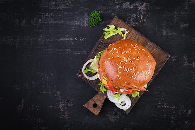 Hamburguesa con pollo hamburguesa carne queso tomate pepino y lechuga sobre fondo de madera Sabrosa hamburguesa Cerrar Vista superior