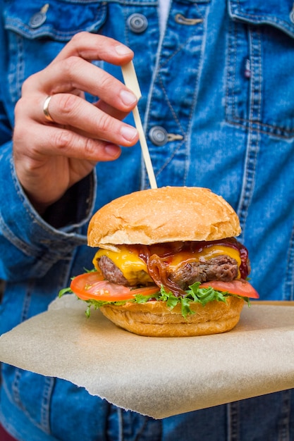 Hamburguesa en primer plano de manos masculinas.