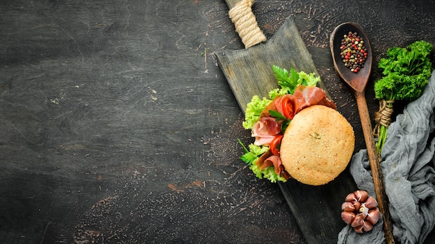 Hamburguesa con prosciutto sobre fondo de madera antiguo Desayuno Vista superior Espacio libre para el texto