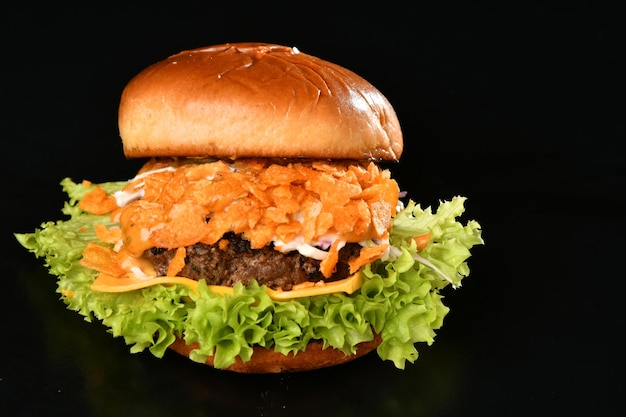 Una hamburguesa con queso con un bollo y lechuga encima