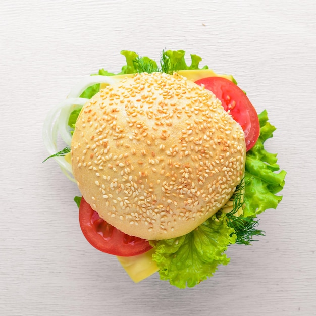 Hamburguesa con queso, carne y cebollas verdes sobre fondo de madera. Vista superior. Espacio libre.