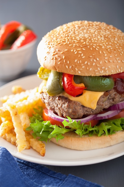 Hamburguesa de queso casera con pimientos, tomate y cebolla.