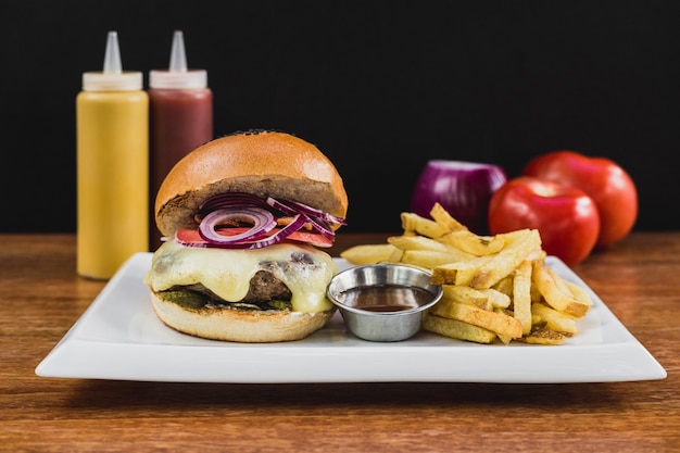 Foto hamburguesa con queso, cebolla, tocino, pepinillo, papas fritas, barbacoa, salsa de tomate y mayonesa