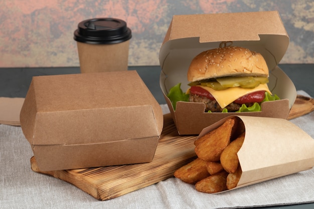 Hamburguesa con queso en envases de papel para una entrega