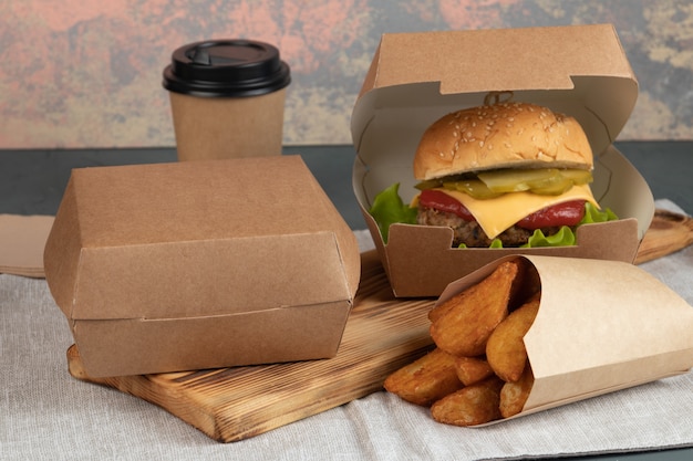 Foto hamburguesa con queso en envases de papel para una entrega