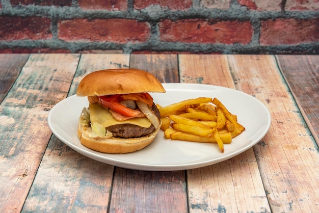 Una hamburguesa con queso con papas fritas en un plato