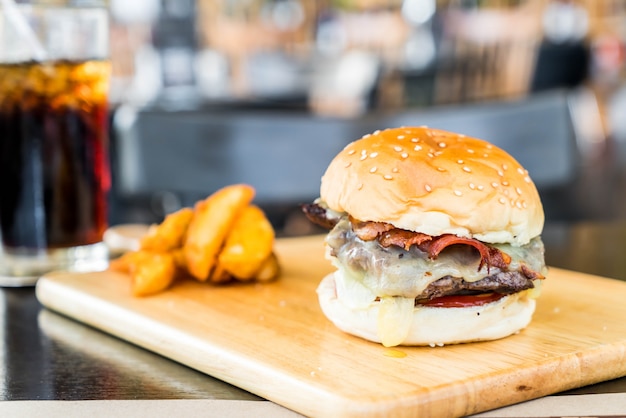 hamburguesa de queso tocino con carne en el tablero de madera en el restaurante