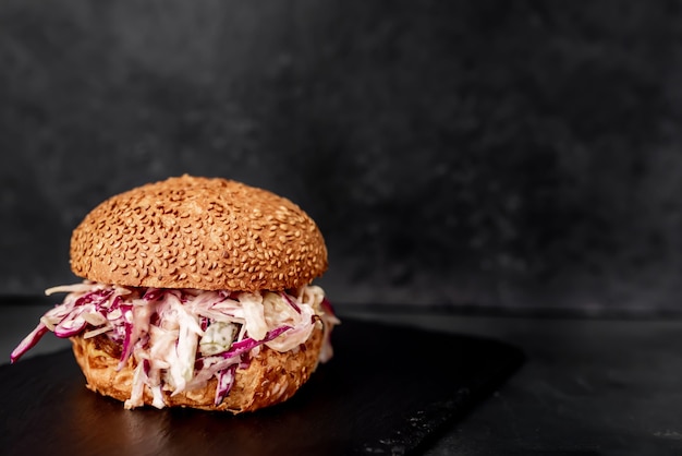 Hamburguesa de rabo de toro y repollo sobre una mesa de piedra