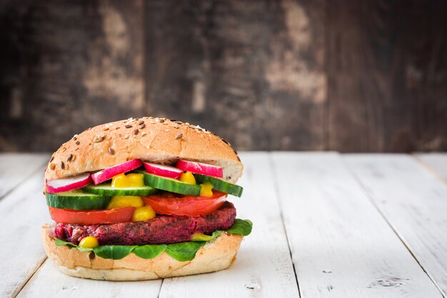 Hamburguesa de remolacha vegetariana en mesa de madera blanca