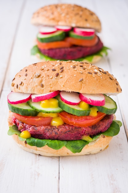 Hamburguesa de remolacha vegetariana en mesa de madera blanca