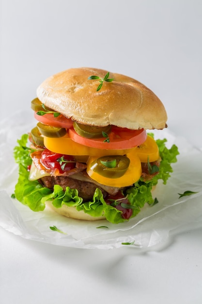 Hamburguesa sabrosa y fresca con tocino, tomate y ternera