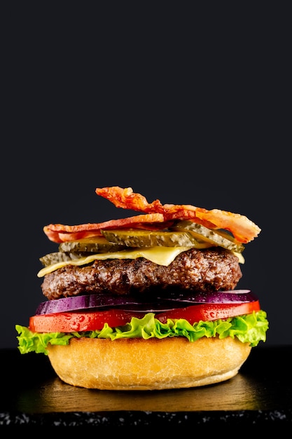 Hamburguesa sabrosa vegetariana fresca sobre un fondo negro. Hacer un burguer por etapas