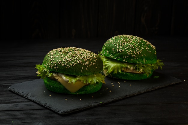 Hamburguesa sabrosa verde fresca en fondo negro