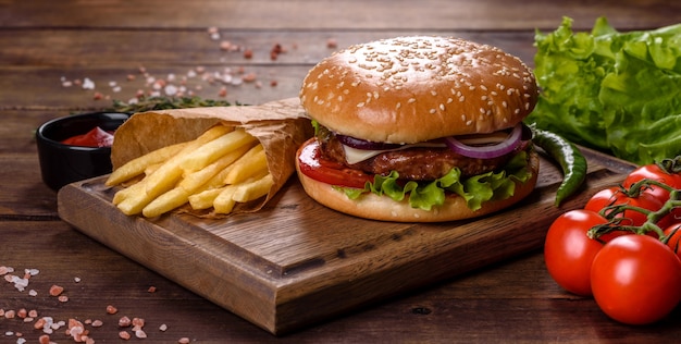 Hamburguesa de ternera artesanal y papas fritas sobre un fondo negro