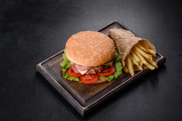 Hamburguesa de ternera artesanal y papas fritas sobre un fondo negro