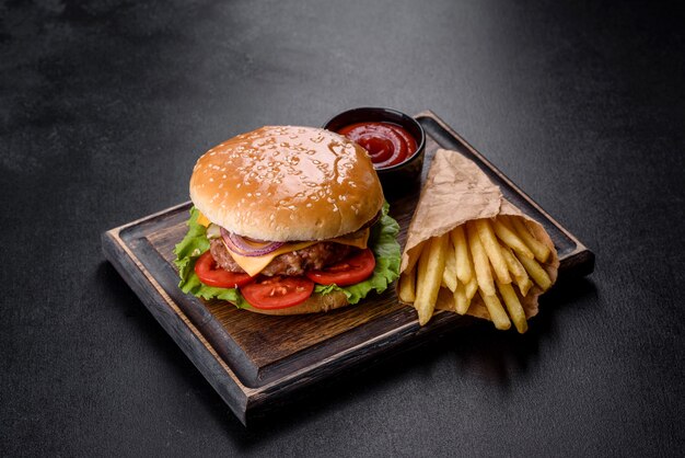 Hamburguesa de ternera artesanal y papas fritas sobre un fondo negro