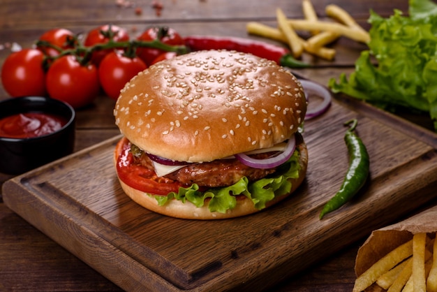 Hamburguesa de ternera artesanal y papas fritas sobre un fondo negro