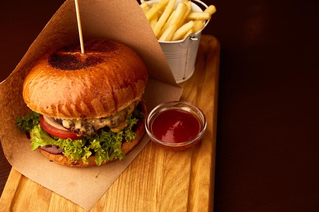 Hamburguesa de ternera fresca y sabrosa con patatas fritas en una mesa de madera en el pub