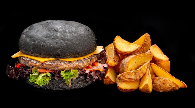 Hamburguesa de ternera negra con patatas fritas aisladas de fondo negro