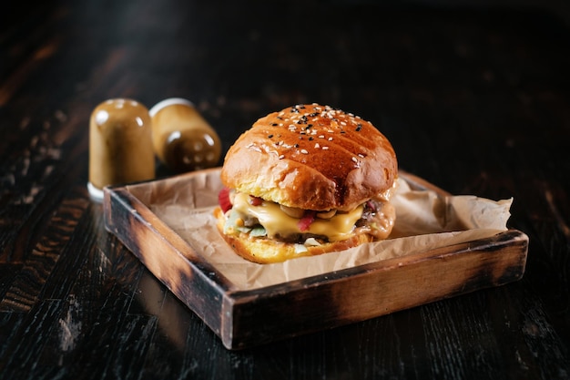 Hamburguesa de ternera con pimienta y sal sobre mesa de madera