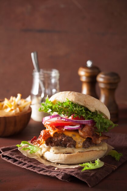 Hamburguesa de tocino y queso con empanada de carne y cebolla de tomate