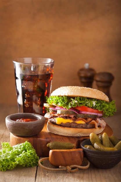 Hamburguesa de tocino y queso con pepinillos, tomate y cebolla