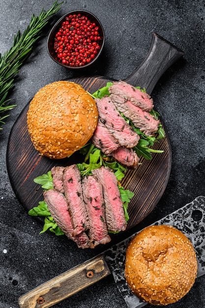 Hamburguesa tradicional de rosbif en rodajas con cebolla, pepinillo, rúcula y espinacas