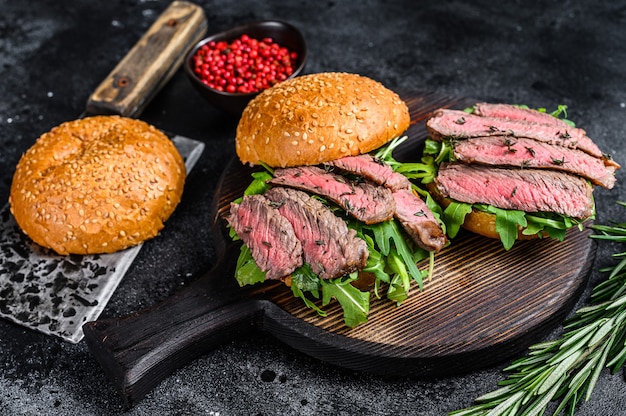 Hamburguesa tradicional de rosbif en rodajas con cebolla, pepinillo, rúcula y espinacas