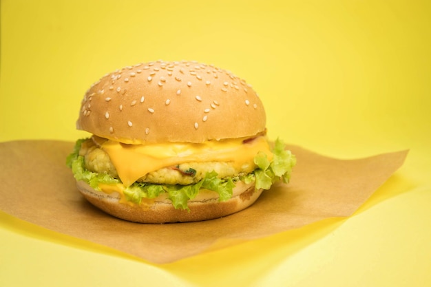 Hamburguesa vegetariana con chuleta de tofu en un servidor de madera y fondo amarillo