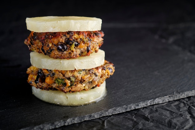 Foto hamburguesa vegetariana de garbanzos con frijoles negros y portabello vegano