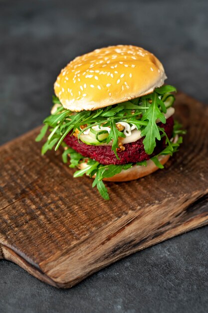 hamburguesa vegetariana con remolacha, garbanzos, pera, rúcula, pepino en una tabla para cortar