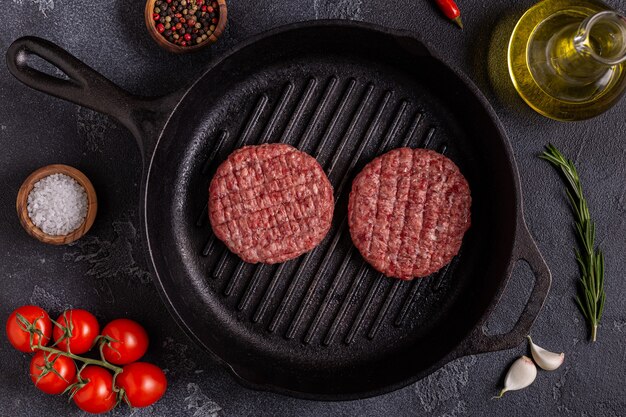 Hamburguesas de carne asada casera picada fresca cruda en una sartén, vista superior