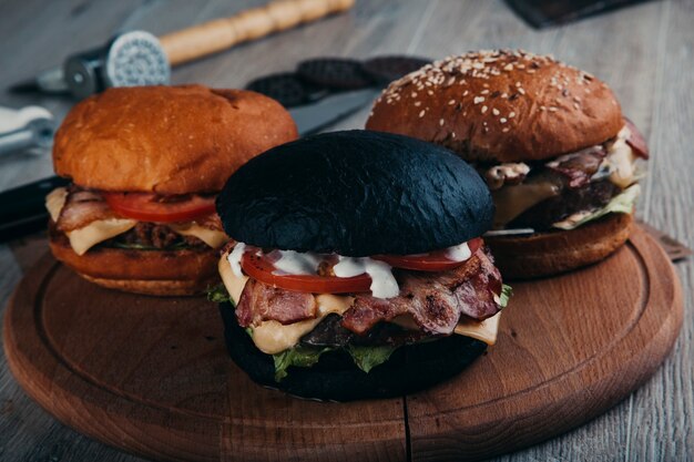 Hamburguesas de carne en tablero redondo de madera con hacha