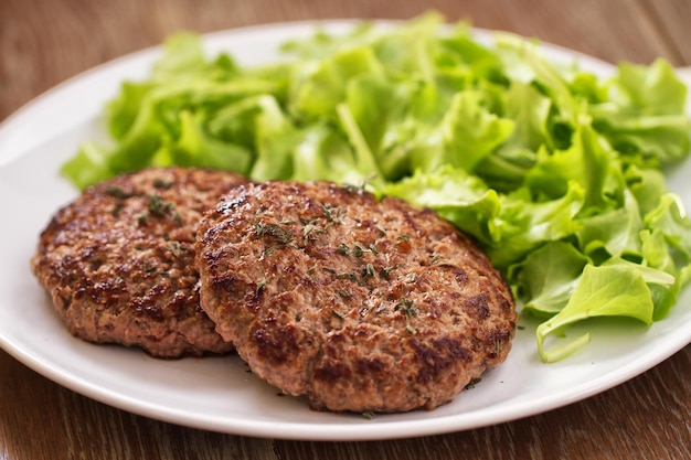 Hamburguesas caseras con ensalada verde en un plato