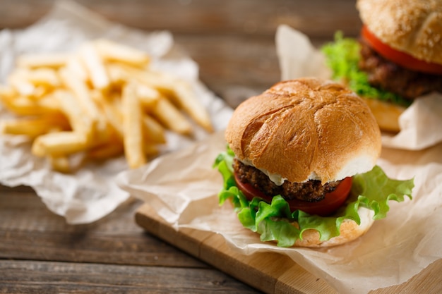 Hamburguesas caseras y papas fritas en mesa de madera