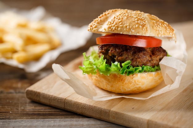 Hamburguesas caseras y papas fritas en mesa de madera