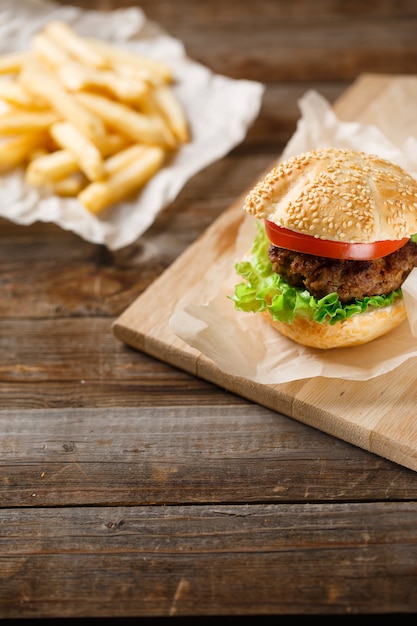 Hamburguesas caseras y papas fritas en mesa de madera