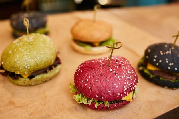 hamburguesas de colores en una tabla de madera comida callejera Bollos pan para hamburguesas con verduras