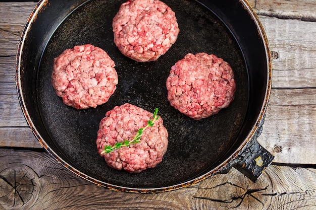 Hamburguesas crudas de carne orgánica en una sartén