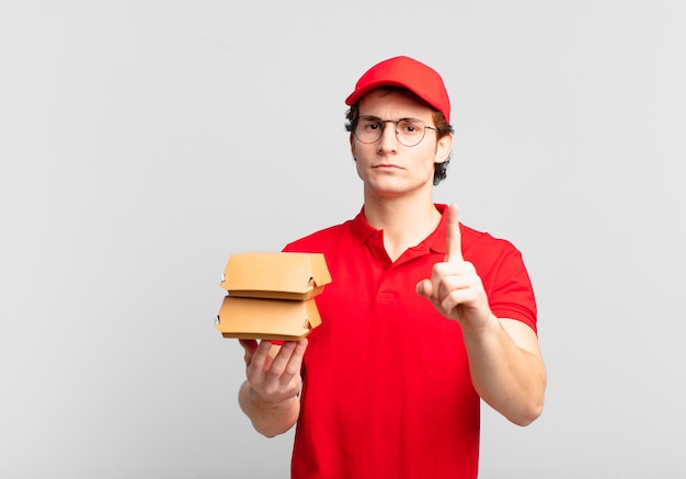 Las hamburguesas entregan al niño sintiéndose enojado, molesto, rebelde y agresivo, moviendo el dedo medio, contraatacando