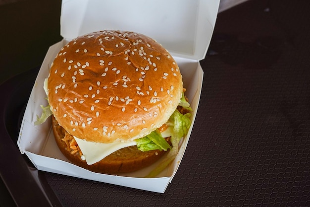 Hamburguesas frescas y sabrosas en un alimentador de caja de papel blanco