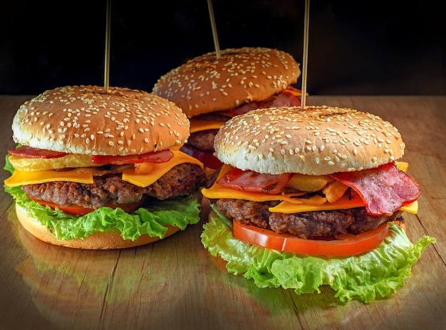 hamburguesas en una mesa de madera con lechuga y queso.