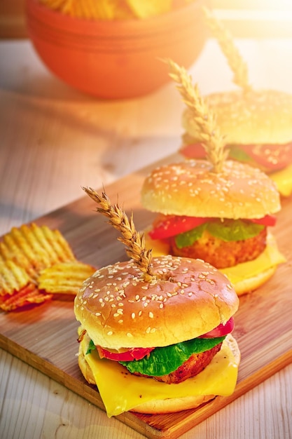 Hamburguesas y papas fritas en tablero de madera en un café soleado