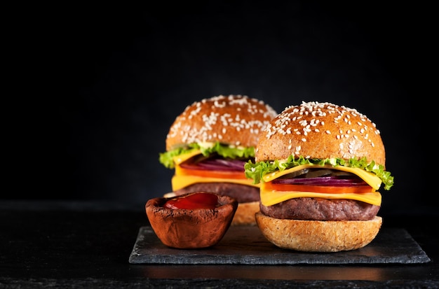 Hamburguesas de ternera hamburguesas con queso en una pizarra negra