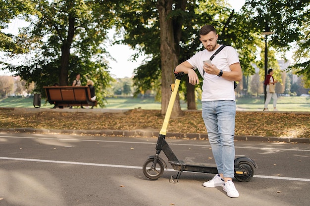 Hamdsome Mann, der während der Pause telefoniert, bevor er auf Escooter fährt